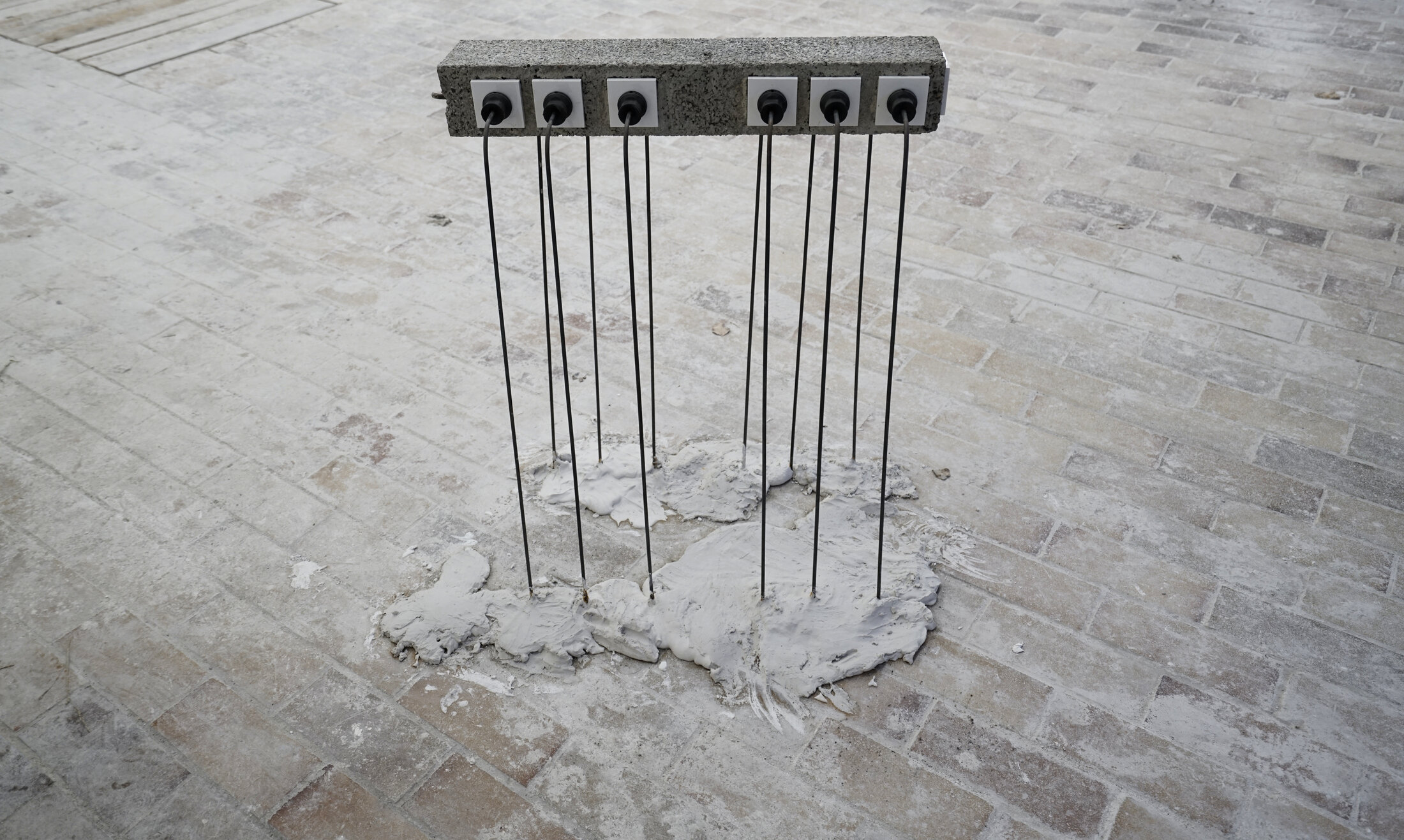 Provider: a concrete beam of sockets carried by thin steel rods that stand in a splash of cast concrete